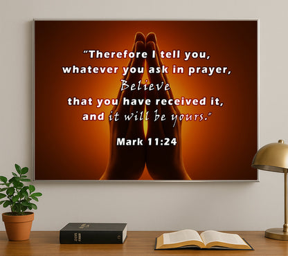 Praying hands with a quote on a wall above a desk with books and a lamp.